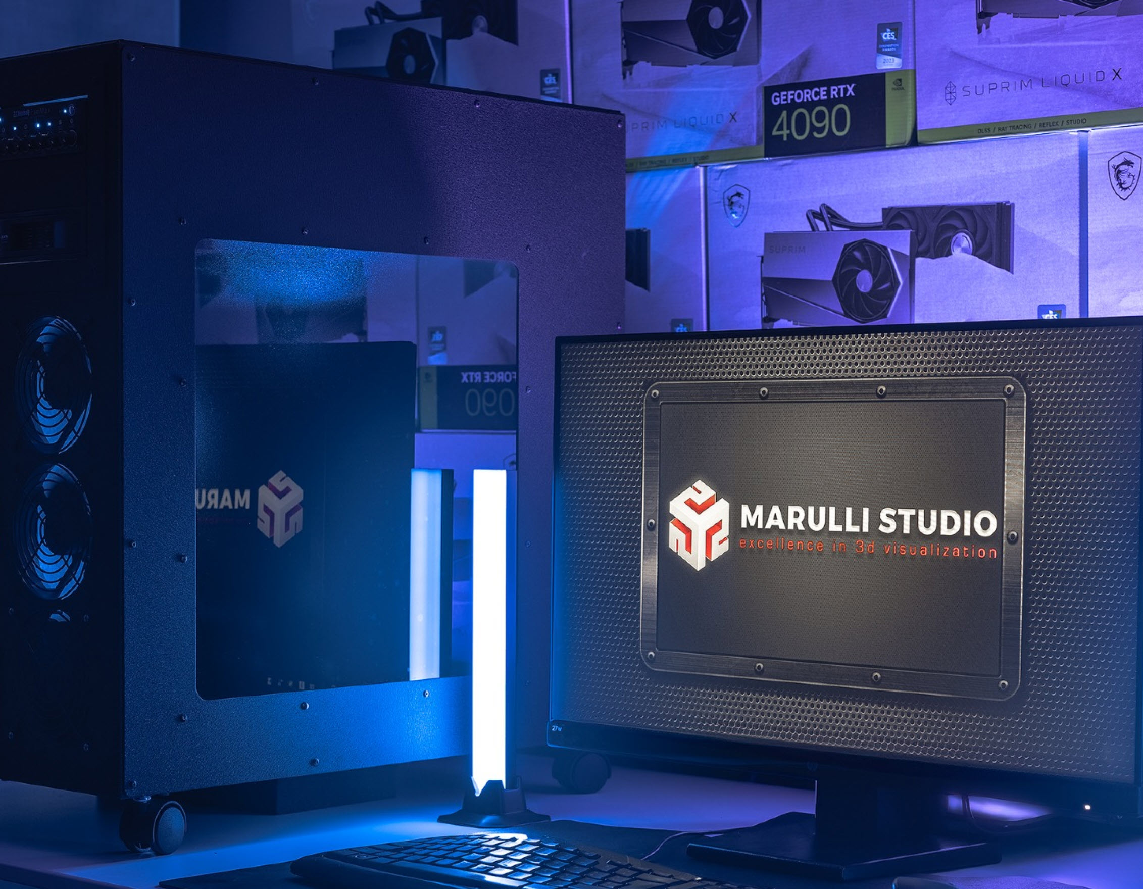 Un bureau montrant des boîtes de cartes graphiques NVIDIA GeForce RTX 4090 en arrière-plan et un écran affichant le logo 'MARULLI STUDIO excellence in 3d visualization'.